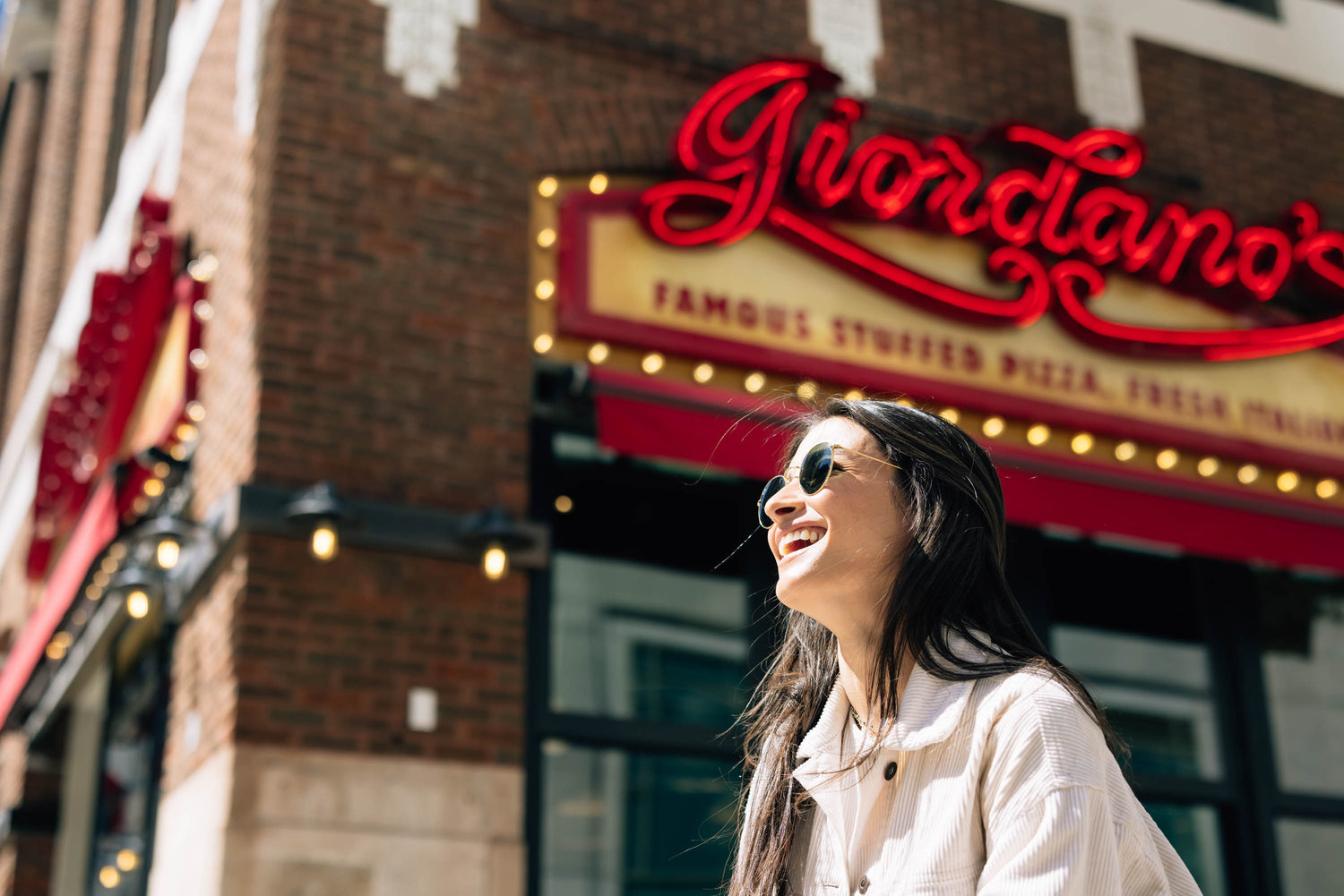 girl smiling in front of Giordano's pizza in Chicago.